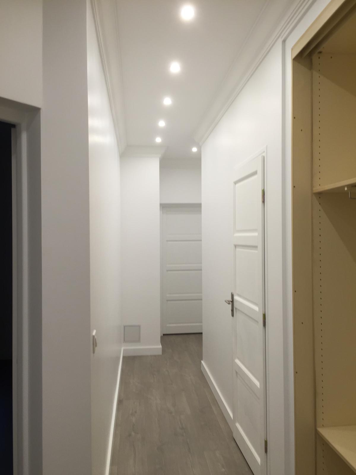 Couloir rénové avec murs blancs et spots encastrés
