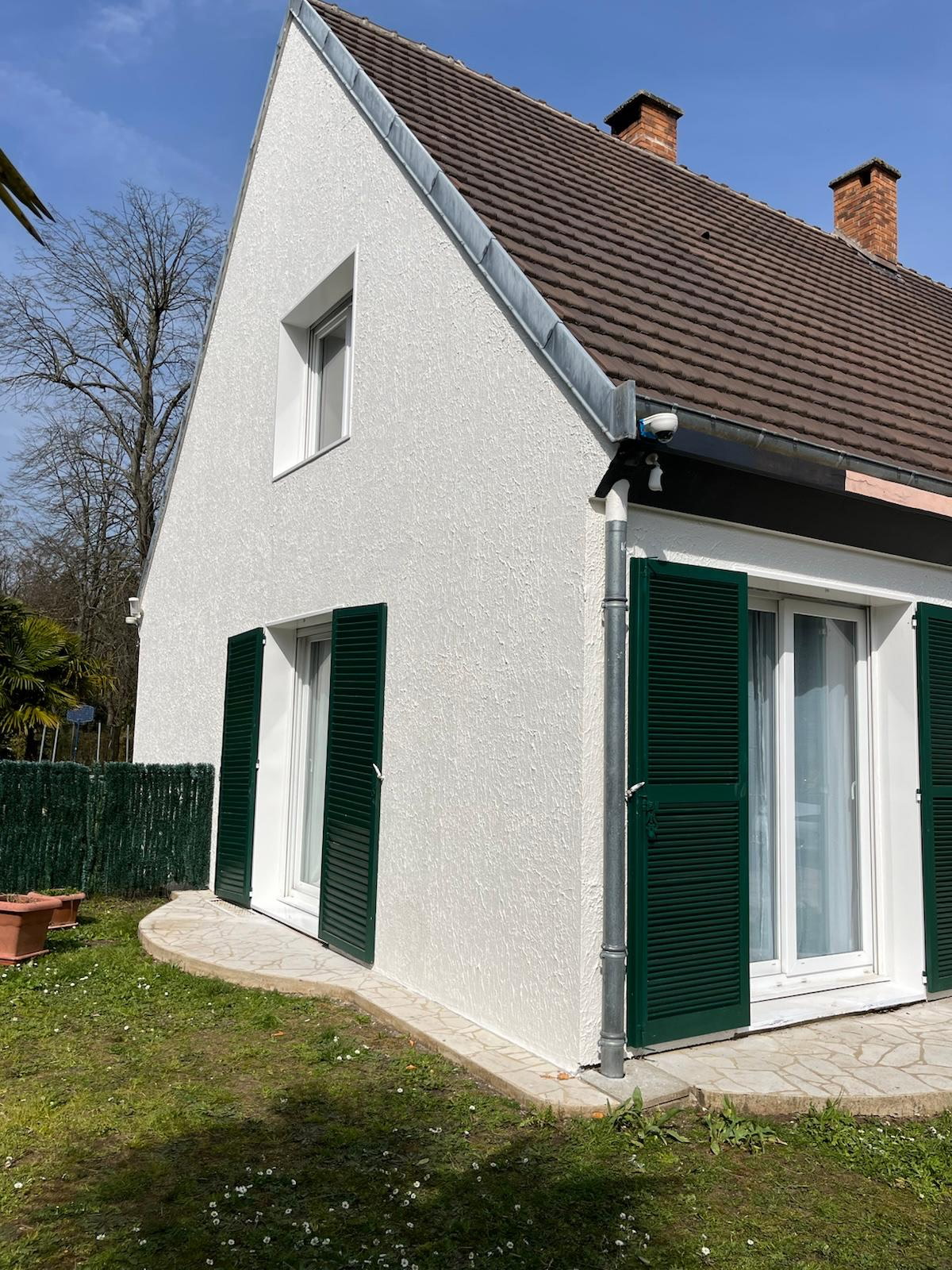 Façade blanche, fenêtres et volets verts