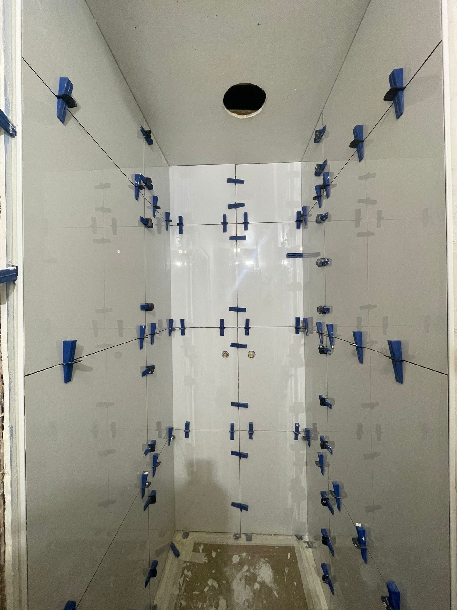 Pose du carrelage mural d’une douche — chantier en cours