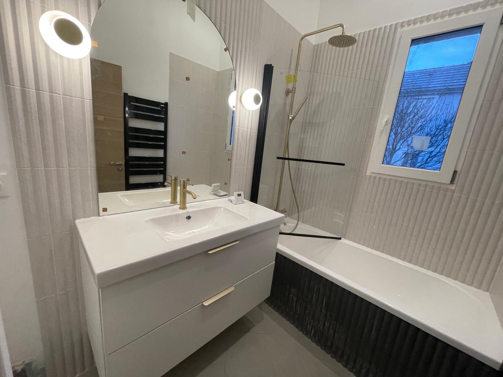 Salle de bains : meuble vasque, baignoire et robinetterie dorée
